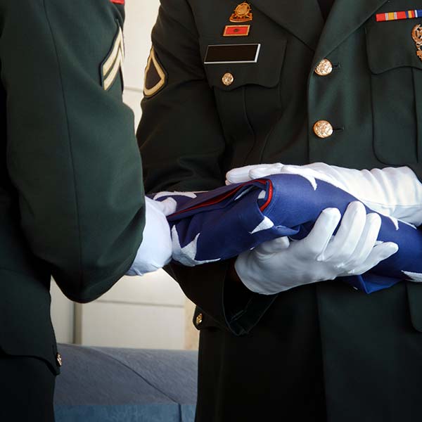 Military Honor Guard Folds United States Flag at Veteran Funeral