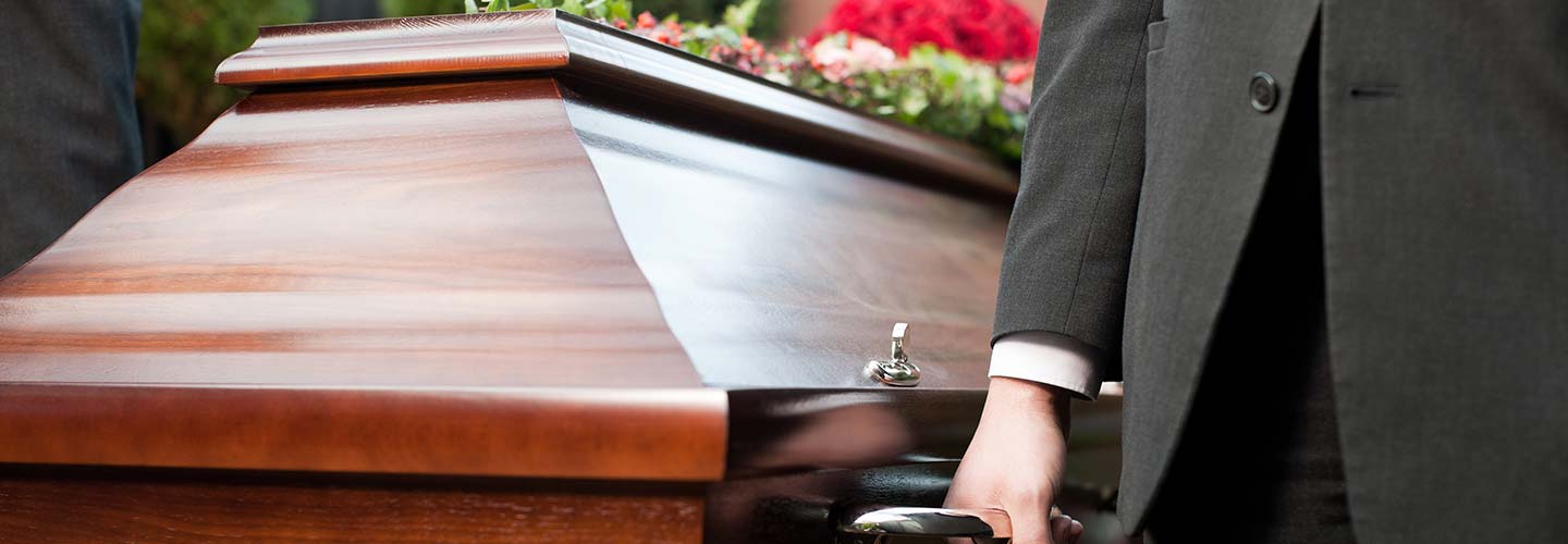 Funeral with a casket carried by coffin bearers