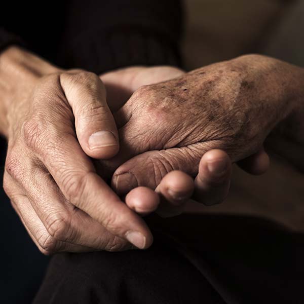 Young man holding a hand of a old woman